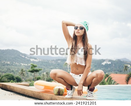 Beautiful young woman in bikini having fun in a pool. Outdoor lifestyle portrait of a sporty girl