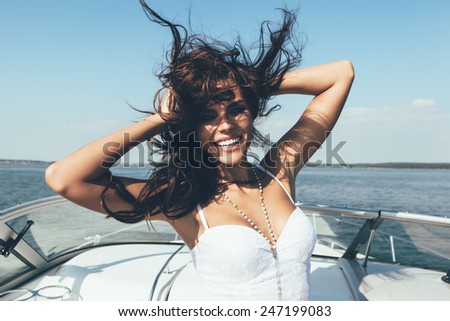 Young happy woman have fun on the luxury boat in open sea in summer. Caucasian female model. Outdoors, lifestyle.