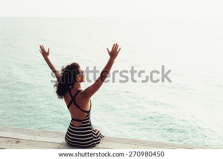 Freedom and happiness woman on pier. Girl enjoying serene ocean nature during travel holidays vacation outdoors