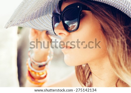 Close-up of face of young summer sexy woman wearing hat  and sunglasses. Outdoors lifestyle portrait