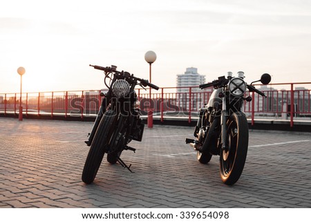 Two vintage custom motorcycles in the parking lot during sunset. Outdoors lifestyle