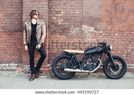 portrait young guy with a beard and mustache with sunglasses and white T-shirt posing on the street vintage man, fashion men, hipster street casual a motorcycle