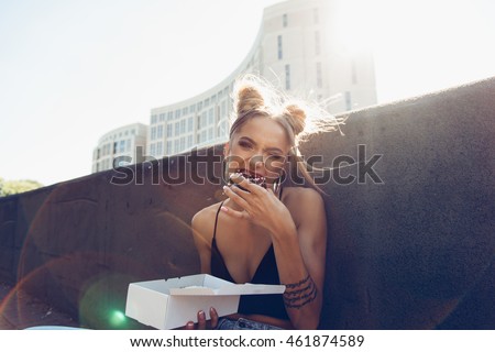 Portrait of hungry young cheeky girl eating donut