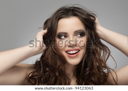 Very beautiful and happy woman hands in her hair pulling.