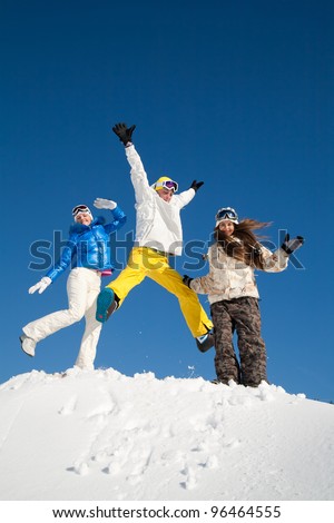 Young people are enjoying the sun and snow, bouncing in the air