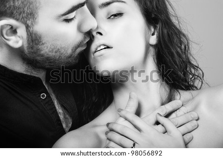 a hot man is kissing his  beautiful young woman