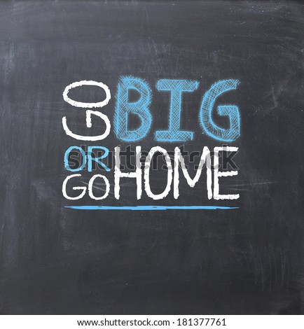 Go big or go home concept on blackboard