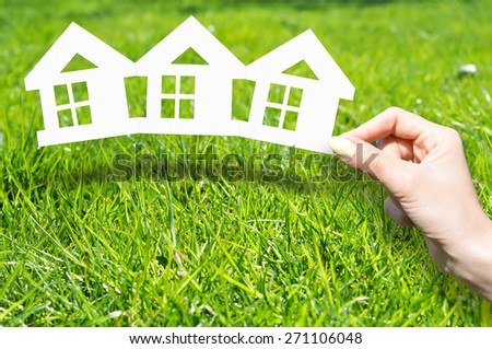 Home insurance concept with hand on green grass