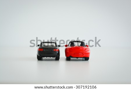Black and red toy cars on white background suggesting a competition
