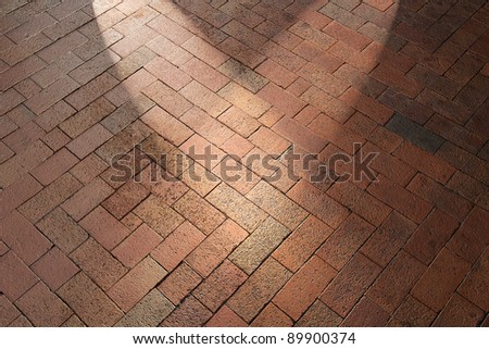 Spotlights shining on red brick pavement walkway patio floor
