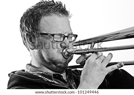 Musician - This is a high contrast black and white image of a you man playing a trombone. Shot on a white background and processed to enhance texture.