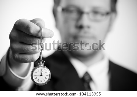 Time / This is a black and white photo of a business man holding out an old pocket watch. Shot with a shallow depth of field. (Focus On Watch)