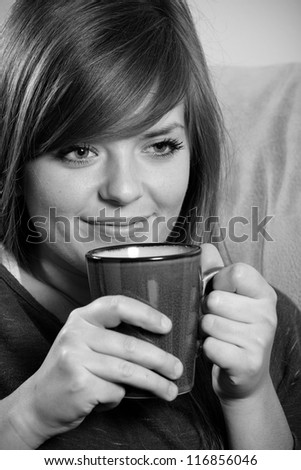 Drinking Coffee - This is a black and white image of a young woman smiling and enjoying a cup of hot coffee.