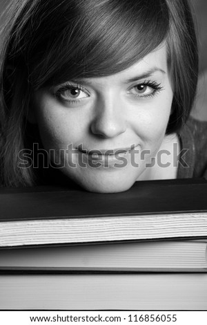 Student - This is a close up black and white shot of a cute student resting her head on a stack of books.