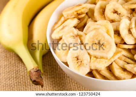 Banana - This is a close up shot of a bowl full of dried banana chips. Shot with a shallow depth of field and vignetting.