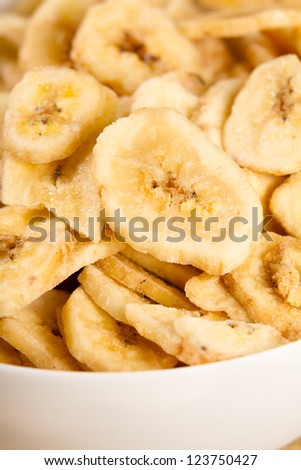 Banana Chips - This is a close up shot of a bowl full of dried banana chips. Shot with a shallow depth of field and vignetting.