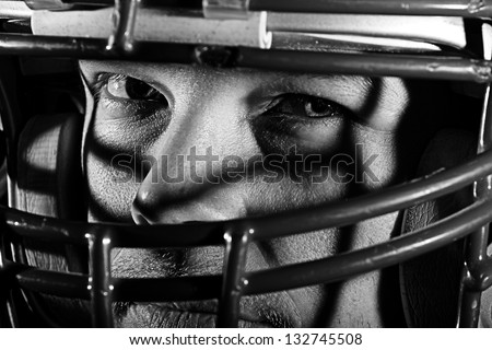Football Player -  A young man with a mean look wearing a football helmet. This is a high contrast processed black and white image to enhance texture.
