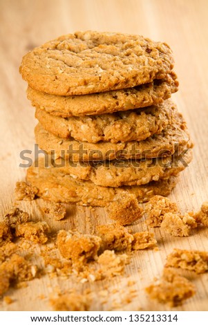 Cookies - This is a stack of oatmeal cookies shot on a wooden cutting board covered in crumbs. Shot with a shallow depth of field.