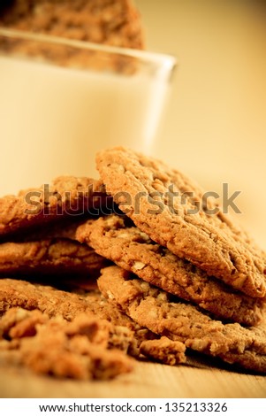 Cookies - This is a photo of a pile of oatmeal cookies with crumbs on a wooden cutting board. Shot with a shallow depth of field with a warm retro color tone.
