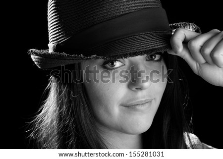 Cute Girl Wearing A Hat - This is a black and white image of a cute young woman wearing a fedora. Shot on a black background.