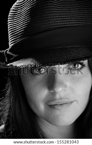 Cute Girl Wearing A Hat - This is a black and white image of a cute young woman wearing a fedora. Shot on a black background.