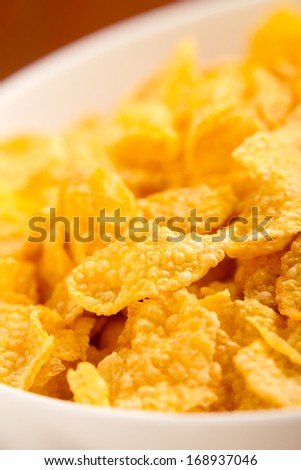 Corn Flaked Breakfast Cereal - This is a close up high key macro shot of a bowl full of corn flake cereal. Shot with a shallow depth of field.
