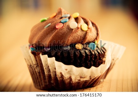 Chocolate Cupcake - This is a shot of a delicious cupcake sitting on a wooden table top. Shot in a warm retro color tone with a shallow depth of field.