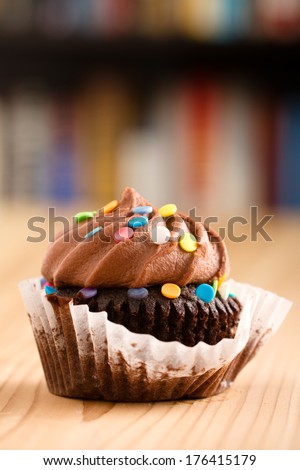 Chocolate Cupcake - This is a shot of a delicious cupcake sitting on a wooden table top. Shot with a shallow depth of field.