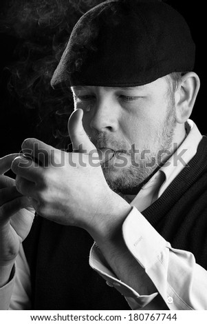 Smoking A Cigar - This is a high contrast black and white image of a young man lighting his cigar. Shot on a black background and processed slightly to enhance detail.