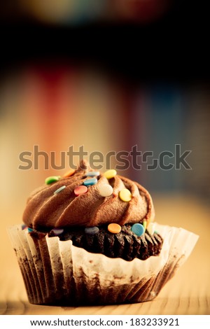 Chocolate Cupcake - This is a shot of a delicious cupcake sitting on a wooden table top. Shot in a warm retro color tone with a shallow depth of field.