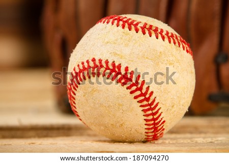 Baseball - This is a shot of an old worn baseball sitting in front of an old glove. Shot with a shallow depth of field.