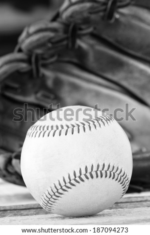 Baseball - This is a high contrast black and white shot of an old worn baseball sitting in front of an old glove. Shot with a shallow depth of field.