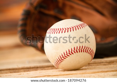 Baseball - This is a shot of an old worn baseball sitting in front of an old glove. Shot with a shallow depth of field. Processed slightly to enhance detail.