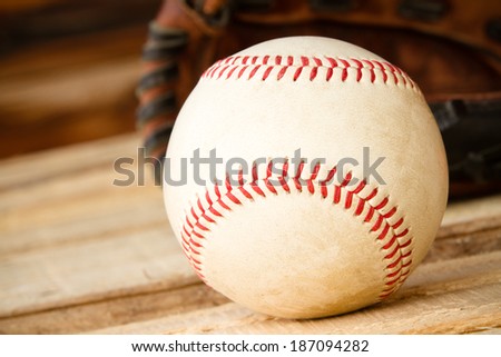 Baseball - This is a shot of an old worn baseball sitting in front of an old glove. Shot with a shallow depth of field.