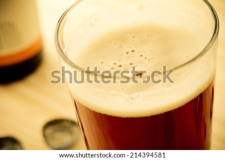 Craft Beer - This is a shot of a cold glass of beer shot at a high angle in a warm, retro color tone. Shot with a shallow depth of field.
