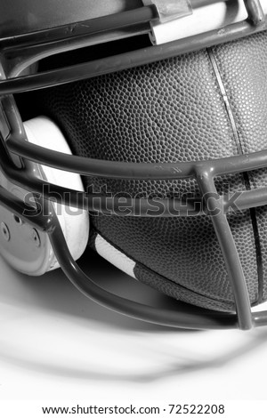 This is a black and white, high contrast shot of an old football helmet with a football inside.