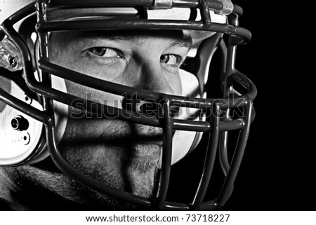 Football Player - This is a high contrast, black and white image of a young man with an intense look on his face wearing a football helmet. Processed to enhance skin texture.