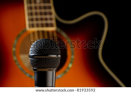 This is a photo of a microphone shot in front of a burnt orange guitar. Shot with a shallow depth of field with focus on the microphone.
