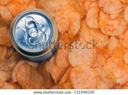 closed can of beer and chips. Focus on the can of beer