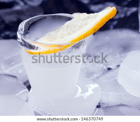 Russian vodka with lemon poured in a glass made of ice