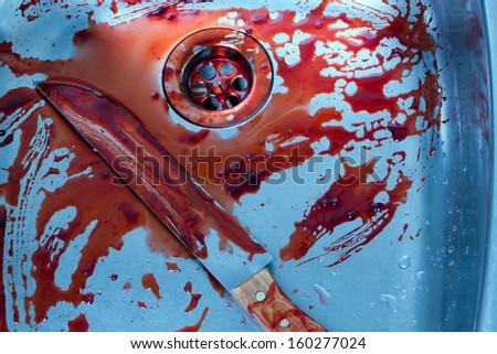 bloody kitchen knife rests in a steel shell. halloween or crime scene. evidence