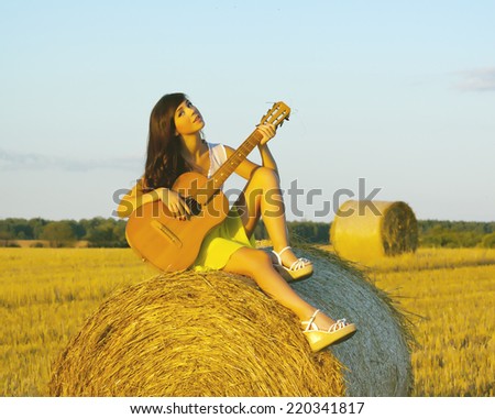 country girl with a guitar. Photo tinted light yellow