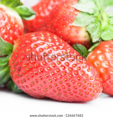 This is a fresh, bright red strawberry shot on a white background. It is heart shaped so it can work nicely with healthy eating concepts.
