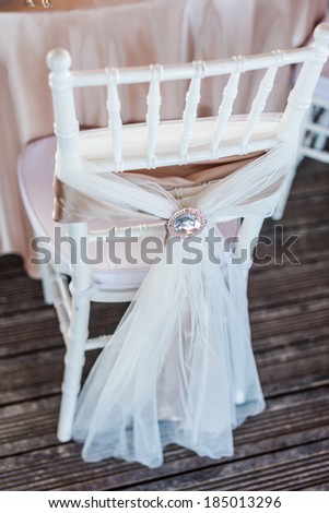 Wedding chairs in row decorated with golden color ribbon