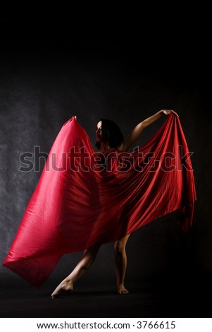 Nude model in studio dancing with red cloth