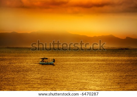 Golden asian sunset over ocean with boat