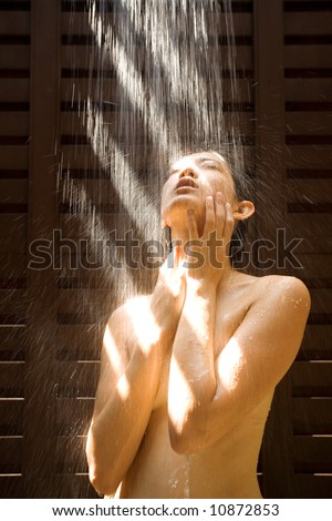 stock photo Naked Asian girl under outdoor strong shower