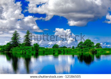 Vivid landscape on bank of river with blue sky in background