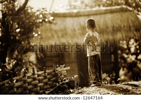 Village boy in early morning looks off to the distance
