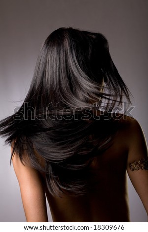 Beautiful dark hair from behind on grey background